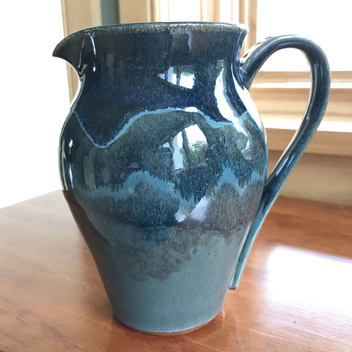 Item 419<br>Tall brown stoneware pitcher, 6.0 in tall x 4.0 in wide. Appropriate for maple syrup, sauces, or as a flower vase. Holds just over 16 oz. of liquid.<br>
