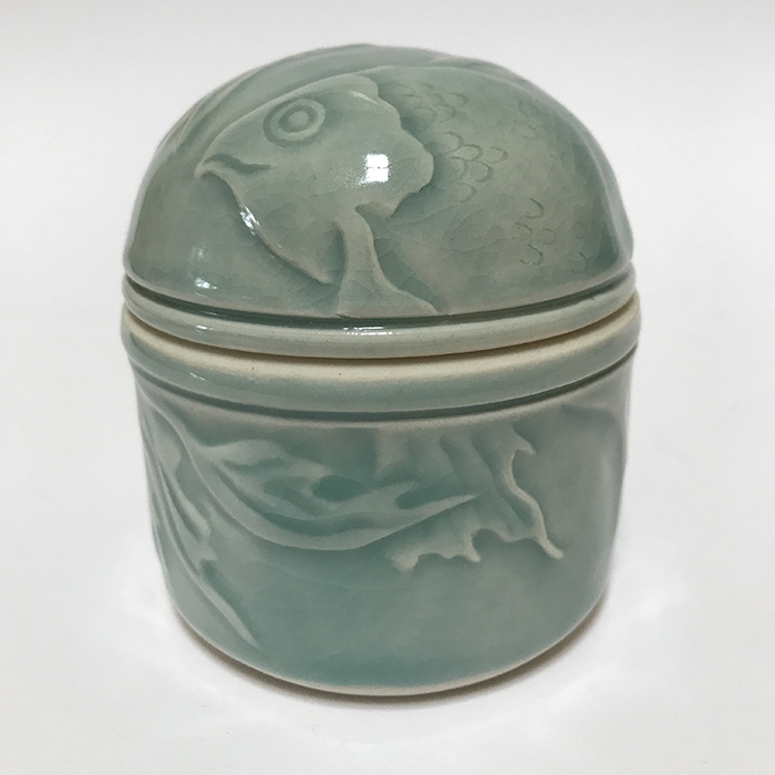 Item 119<br>Porcelain lidded pot with carved fish in an aqua celadon glaze<br>3.0 in tall x 2.75 in wide<br><b>Sold</b>