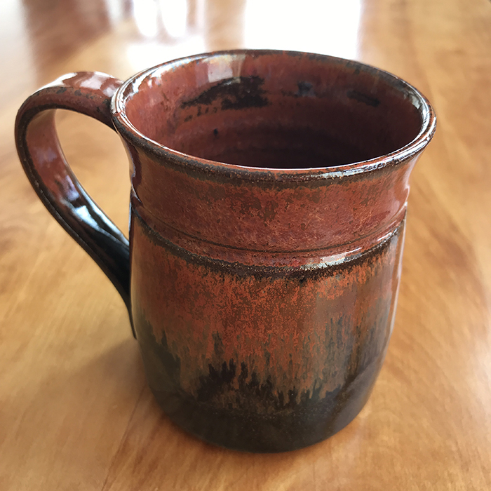 Item 403<br>Red/Black Glazed Coffee or Tea Mug on brown clay, 3.75 in tall x 3.0 in wide. Holds just over 8 oz of liquid<br><b>Sold</b>