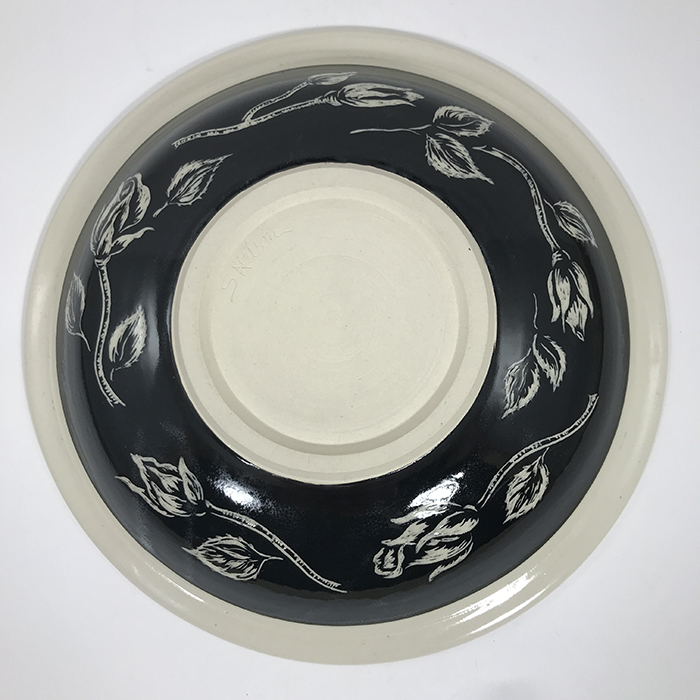 Item 651b<br>Black sgraffito bowl with roses, design on bottom of bowl<br><b>$140</b>